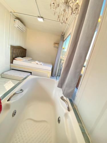 a bathroom with a bath tub and a bed at Pousada São Miguel Beach Beira Mar in Penha