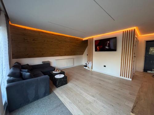a living room with a couch and a tv at Riverside A-frame in Borsa