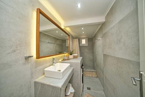 ein Badezimmer mit Waschbecken und Spiegel in der Unterkunft Filoxenia MG Amazon Home in Nafplio