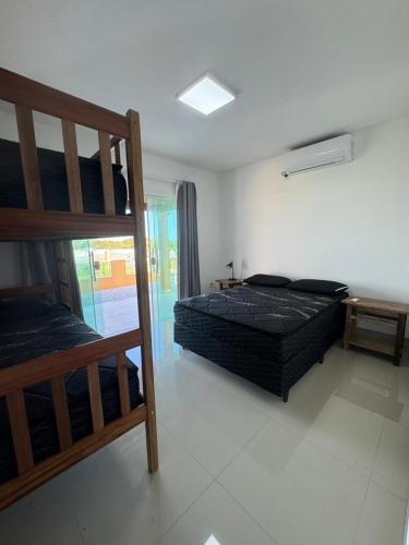 a bedroom with two bunk beds and a balcony at Faith Home 4 in Arraial do Cabo