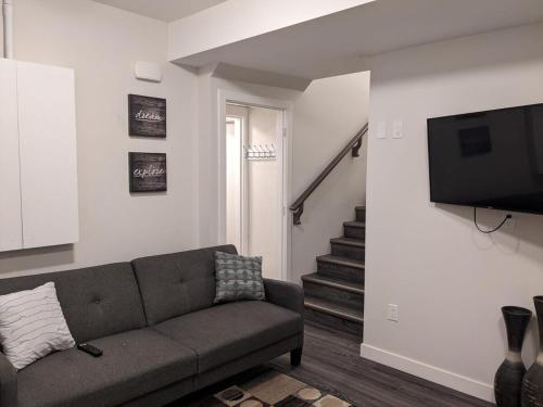 ein Wohnzimmer mit Couch und Flachbildfernseher in der Unterkunft MegaVille in Saskatoon