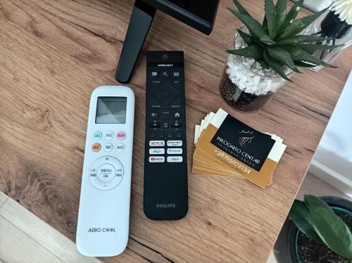 a remote control and a cell phone sitting on a table at INKOGNITO Centar 39 in Brčko