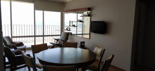 a room with a table and chairs and a television at HAVANNA APART frente al mar in Mar del Plata