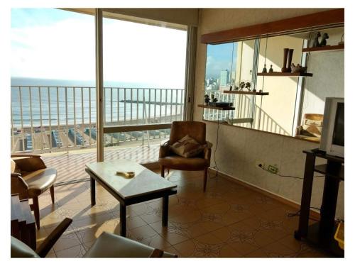 una sala de estar con una gran ventana con vistas a la ciudad en HAVANNA APART frente al mar, en Mar del Plata