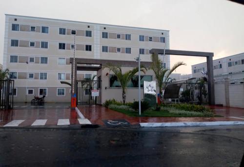 Un gran edificio blanco con palmeras delante. en Apto perto Shopping, Castelli, Unitri, AABB, Palácio de Cristal, en Uberlândia