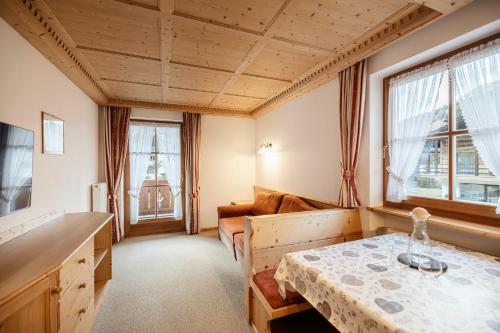 een woonkamer met een tafel en een bank bij Chalet Bel Plan in Ortisei