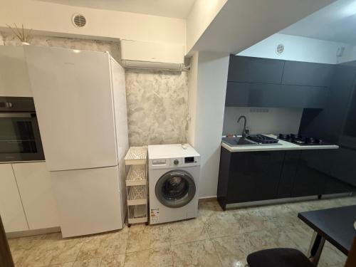a kitchen with a washing machine and a washer at Cozy apartment in Craiova
