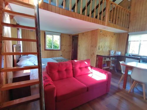 Una sala de estar con un sofá rojo y una litera. en Cabañas CyG - Chaitén, en Chaitén