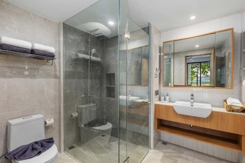een badkamer met douche, toilet en wastafel bij Laguna beachside residences by My home Phuket in Bang Tao Beach