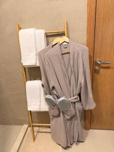 a jacket hanging on a towel rack next to a door at Golf view living by FlamingoAmber Dubai in Ajman