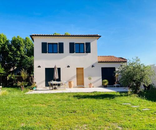 een wit huis met een gazon ervoor bij La Petite Bastide en Provence in Noves