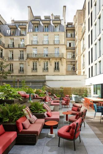 a patio with chairs and tables and a building at citizenM Paris Champs-Élysées in Paris