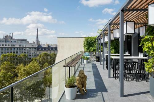 a dog sitting on a balcony with a view of the eiffel tower at citizenM Paris Champs-Élysées in Paris