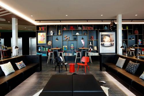 a living room with couches and tables and chairs at citizenM Copenhagen Radhuspladsen in Copenhagen