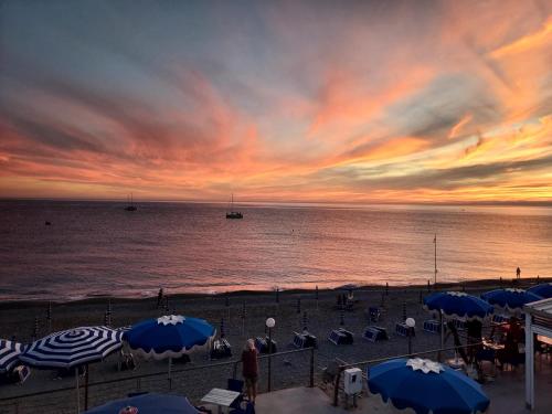 a beach with umbrellas and the ocean at sunset at Casa di Doria in Deiva Marina