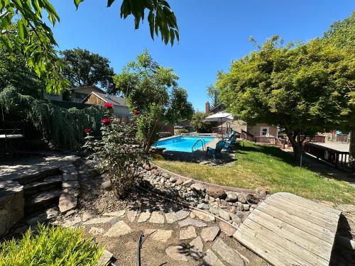 een achtertuin met een zwembad en een keermuur bij Medford Home And 2 Condos With Pool in Medford