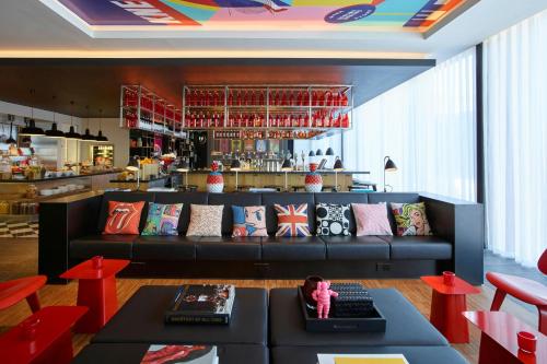 a living room with a couch and a bar at citizenM London Shoreditch in London