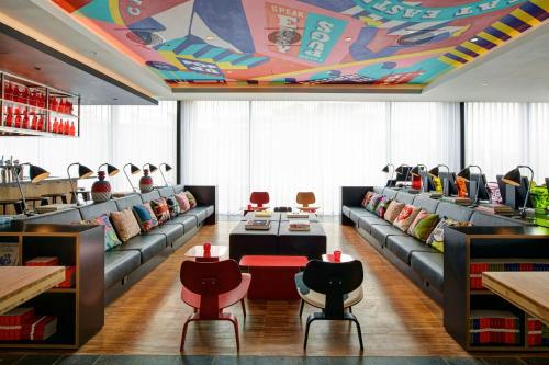 a restaurant with couches and chairs and a colorful ceiling at citizenM London Shoreditch in London