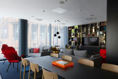 een woonkamer met een bank, een tafel en stoelen bij citizenM Glasgow in Glasgow