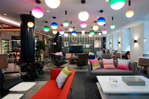 a lobby with couches and tables and colorful lights at citizenM Geneva in Geneva