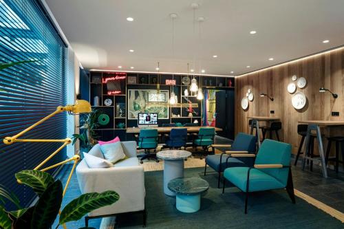 a lobby with chairs and a table and a bar at citizenM Geneva in Geneva