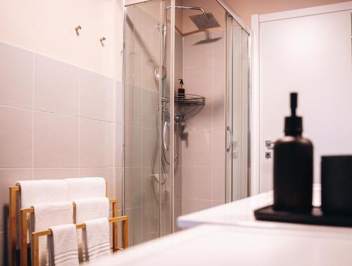 une salle de bain avec douche et serviettes sur le comptoir dans l'établissement 203 Aosta Apartment, à Aoste