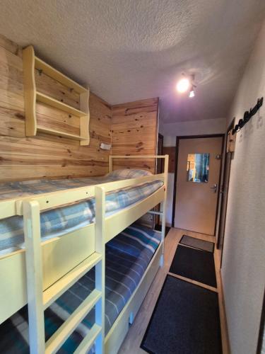 a room with two bunk beds and a hallway at Appt Rez-de-chaussée 4 pers in Orcières