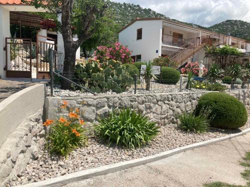 a garden with flowers and plants in front of a house at Apartments in Sveti Juraj 27785 in Burnjak