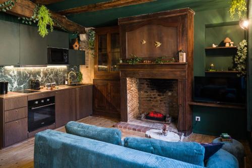 Una sala de estar con chimenea y sofás azules. en Le Sous-Bois, une parenthèse nature, en Bergerac