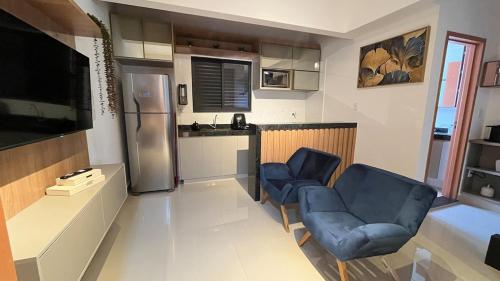 a kitchen with two blue chairs and a refrigerator at 407-3 · Duplex Sossego in Anápolis