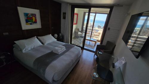 a bedroom with a bed and a view of the ocean at Laura del Mar Hotel Boutique in Concón