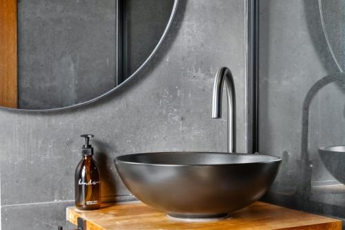 a bathroom with a bowl sink and a mirror at Luxury Container and Cabin with Outdoor Bath in Wanaka