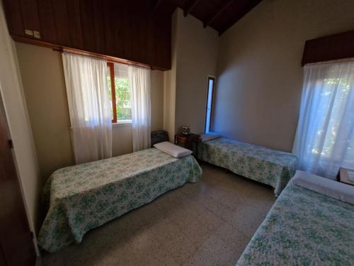 ein Zimmer mit zwei Betten und einem Fenster in der Unterkunft Casa Castelli in Mar de Ajó