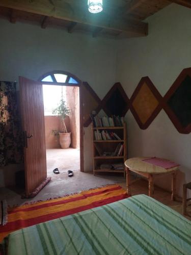 a bedroom with a door open to a room with a table at Maison diyafa in Guelmim