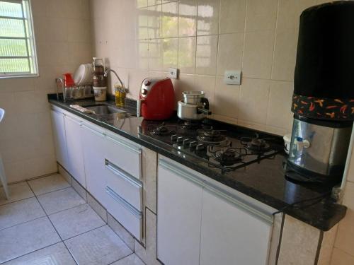 a kitchen with a stove and a counter top at Home office solteiro aconchegante no Centro de Poços de Caldas in Poços de Caldas