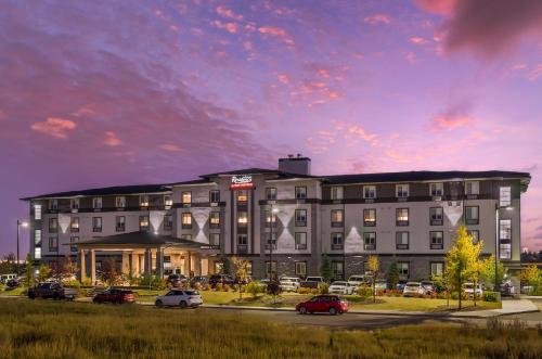 a large building with cars parked in a parking lot at Executive Residency by Best Western Calgary City View North in Calgary