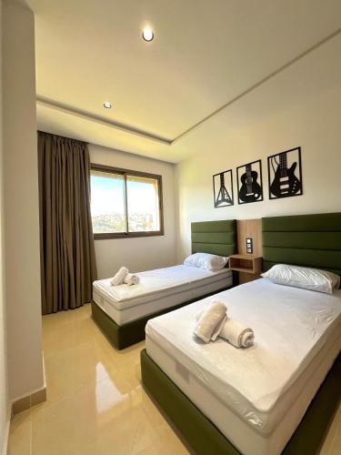 a bedroom with two beds and a window at appartement 3 chambres à côté de stade in Tangier