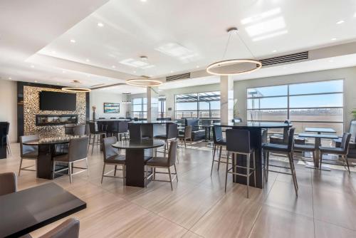 a dining room with tables and chairs and windows at Executive Residency by Best Western Calgary City View North in Calgary