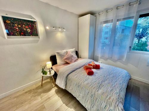 a bedroom with a bed with two red stuffed animals on it at Neuf et lumineux 2min Gare - 20min Paris in Maisons-Laffitte