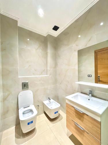 a bathroom with a toilet and a sink at appartement 3 chambres à côté de stade in Tangier