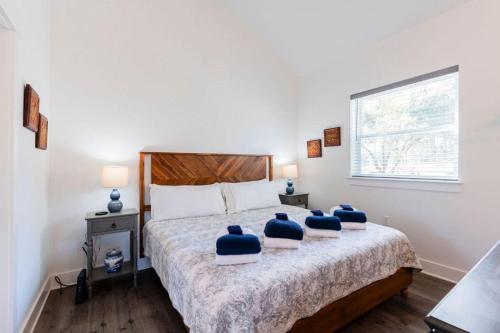 a bedroom with a bed with blue pillows on it at Charming Old Town Loft, nestled in the Heart of Historic Bluffton, SC in Bluffton