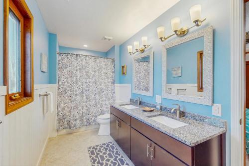 a bathroom with a sink and a toilet and a mirror at Lacado Brista in Virginia Beach