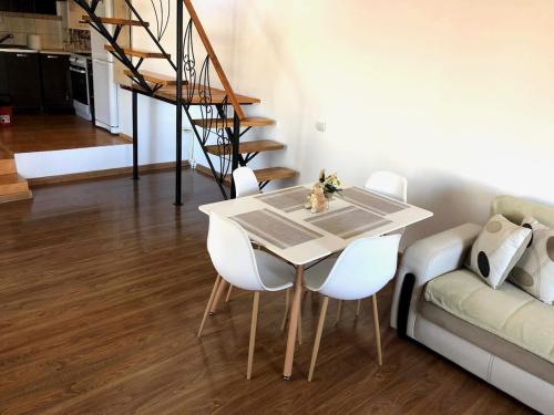 Un comedor con una mesa y sillas blancas. en Casa Alex, en Hunedoara