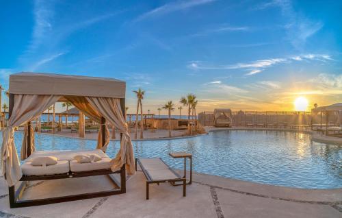 a bed and a chair in front of a swimming pool at 1BR 1BA Ocean View Las Palomas Phase 1 Bld Ruby in Puerto Peñasco