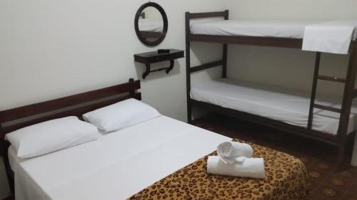 a bedroom with two bunk beds and a mirror at Nova Pousada do Canal in Cabo Frio