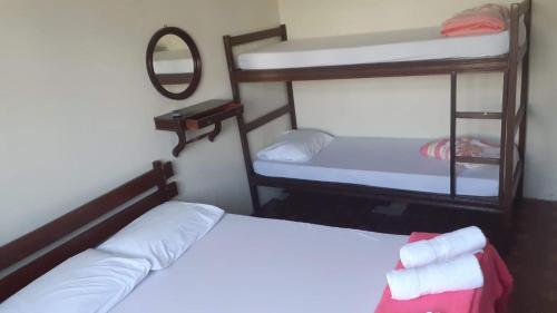 a bedroom with two bunk beds and a mirror at Nova Pousada do Canal in Cabo Frio