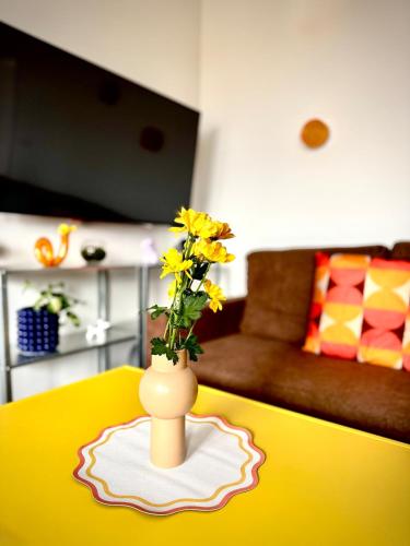 a yellow table with a vase with yellow flowers on it at New flat close to center in Komárov