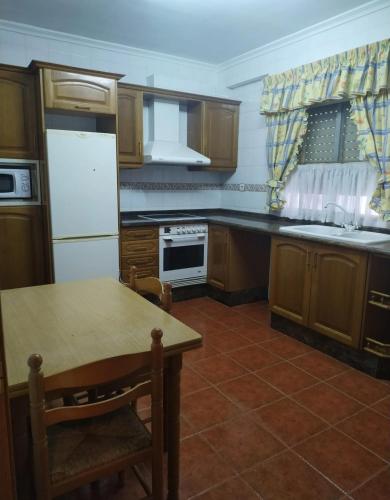 a kitchen with a table and a white refrigerator at Toscana Valenciana 2 in Fontanares