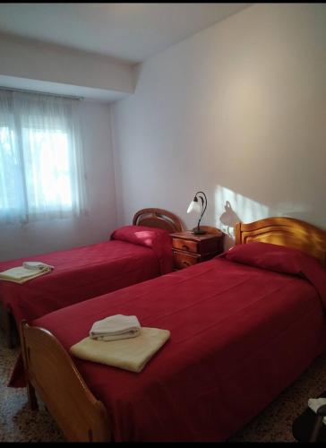 - 2 lits dans une chambre avec des draps rouges dans l'établissement Toscana Valenciana 2, à Fontanares