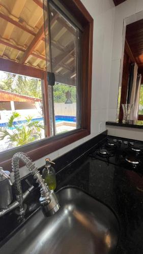 a sink in a kitchen with a window and a sink at Casa - Guarapari in Guarapari